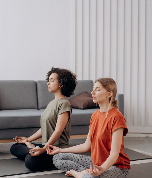 Woman in a peaceful yoga pose in a softly lit room.