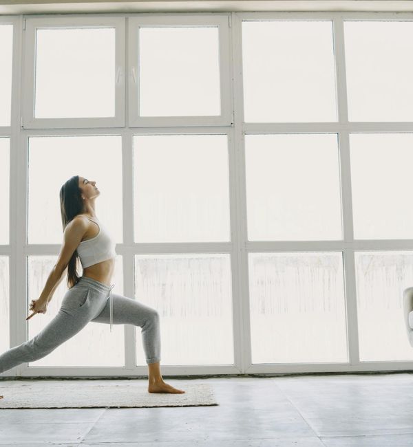 Woman performing a stretching yoga pose on a bright yoga mat.